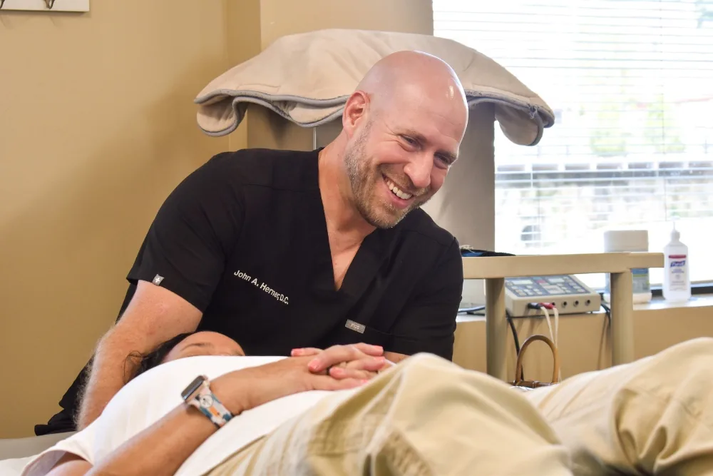 Dr. John Herner talking with a patient during an adjustment at Herner Chiropractic in Nashua, NH